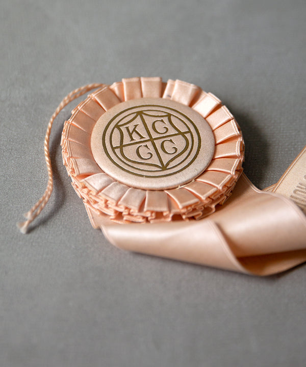 slideimg The satin covered button is foil stamped with a gold KCCC emblem.